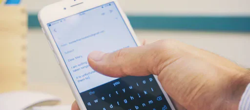 Hands typing on a smartphone.