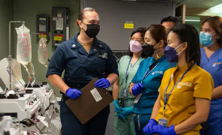 Medical staff wearing masks beside laboratory equipment.