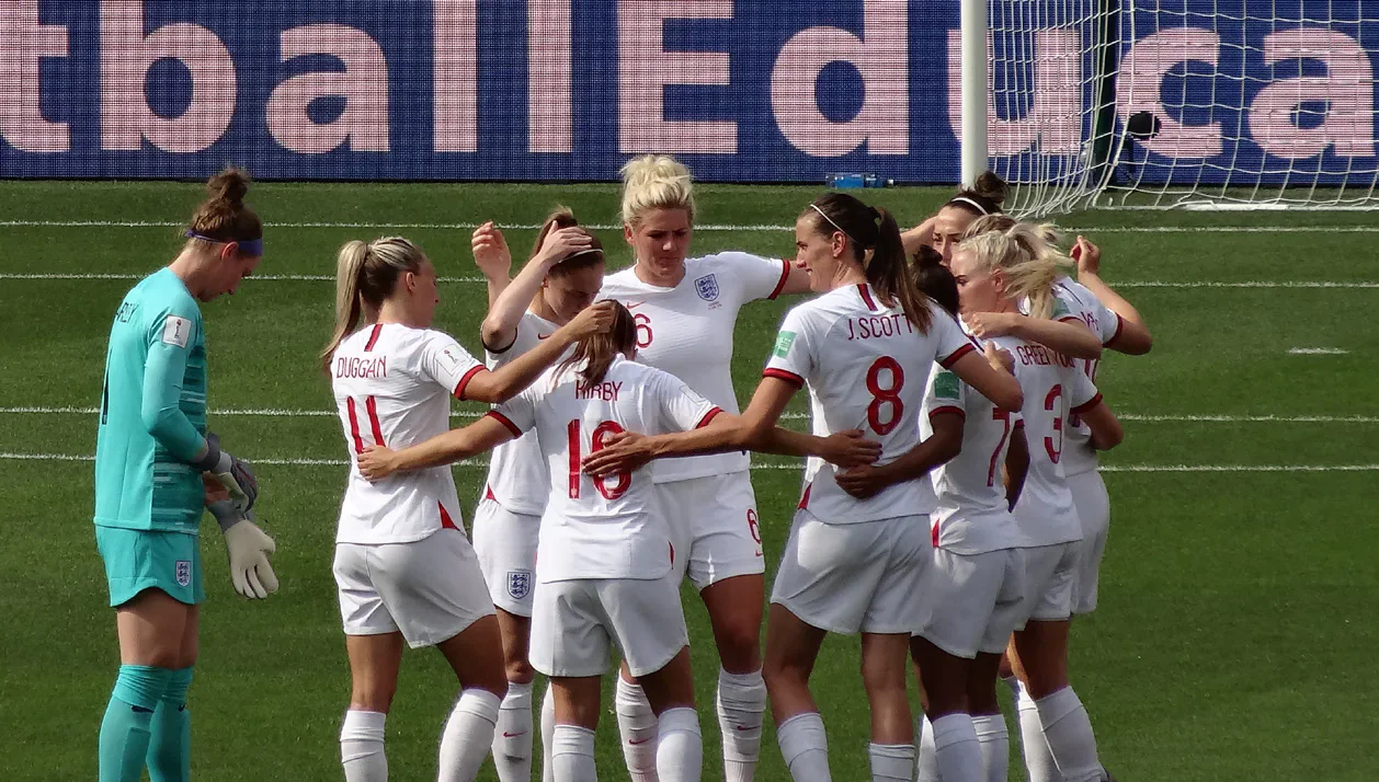 England women’s football players gathered on a pitch.