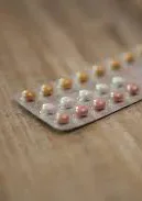 A blister pack of pills on a wooden surface.