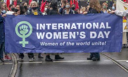 Marchers holding an International Women’s Day banner.