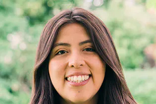 Angie Flores smiling outdoors.