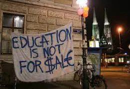 A protest sign in Vienna reads “Education is not for sale”.