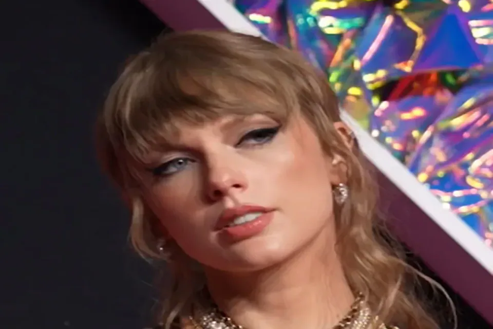 Taylor Swift wearing a black dress and layered necklaces