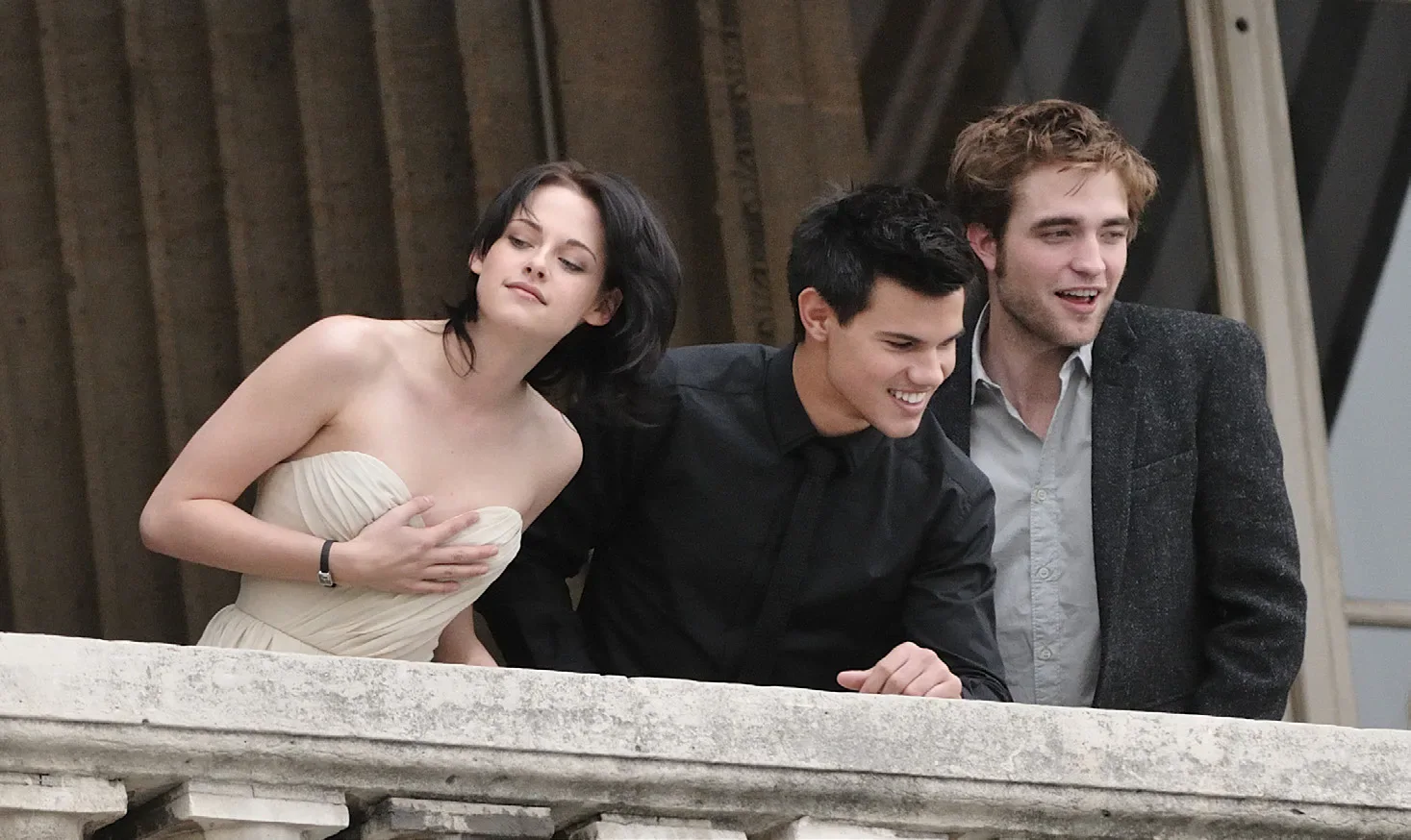 Kristen Stewart, Taylor Lautner and Robert Pattinson standing together on a balcony