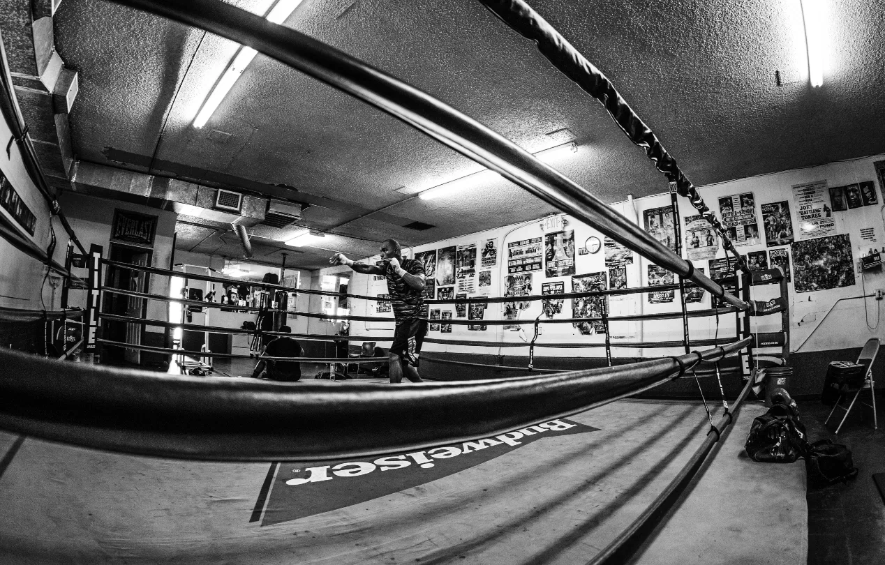 A boxer training alone inside a boxing ring