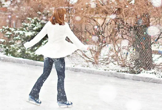 Person ice skating outdoors in falling snow