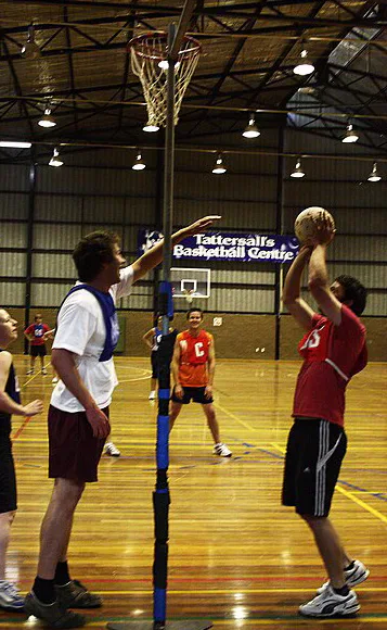 Players competing in an indoor netball game