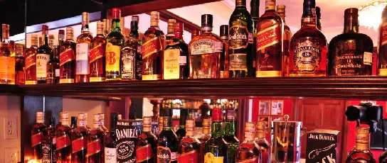 Shelves of bottles behind a bar