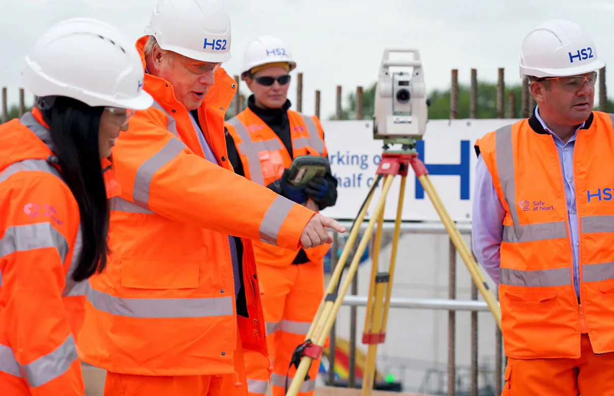 Workers in orange high-visibility clothing and HS2 hard hats at a rail construction site