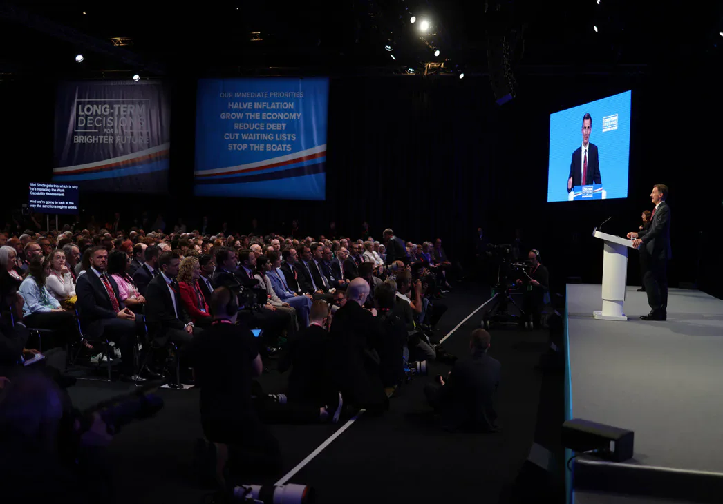 Rishi Sunak speaking on stage to an audience at the Conservative Party conference