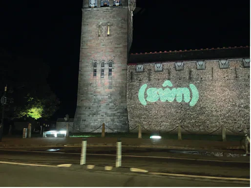 Sŵn festival logo projected onto a church at night