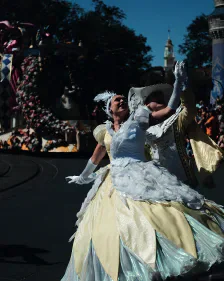 A costumed parade performer in a white and yellow dress outdoors