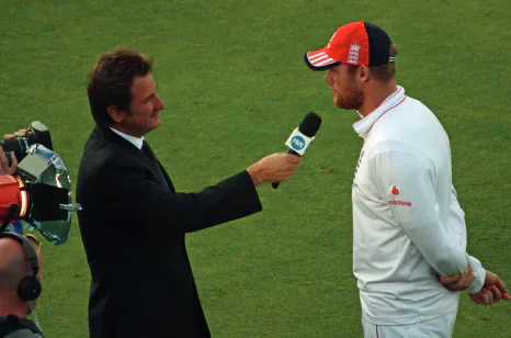 Freddie Flintoff in cricket whites being interviewed on a cricket field