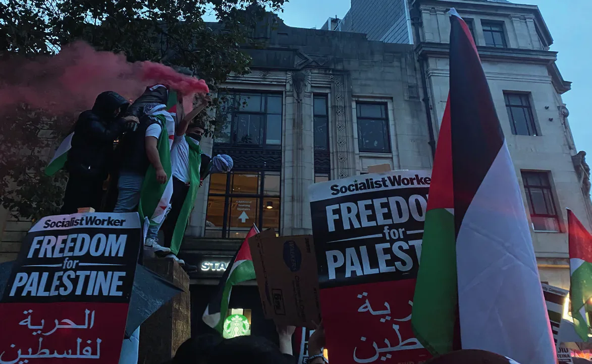 Pro-Palestine protesters holding flags and placards in Cardiff