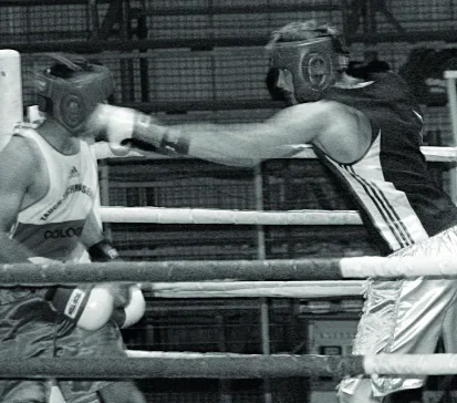 Two boxers competing in a boxing ring
