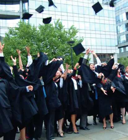 Graduates throwing mortarboards into the air