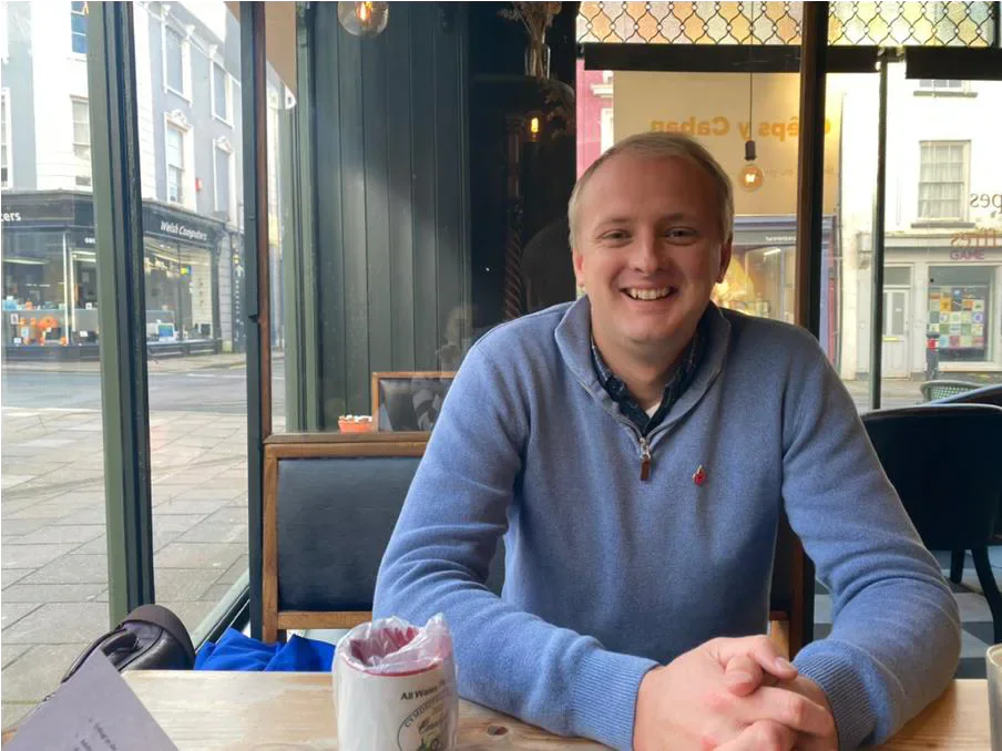 Ben Lake seated at a table in a café