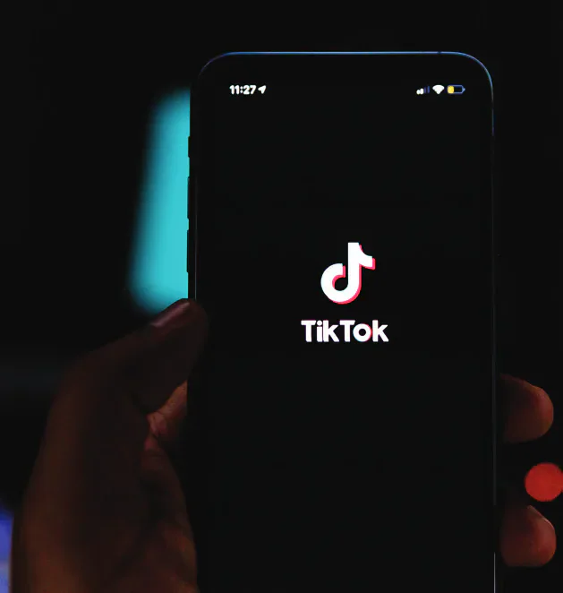 A hand holding a phone displaying TikTok.