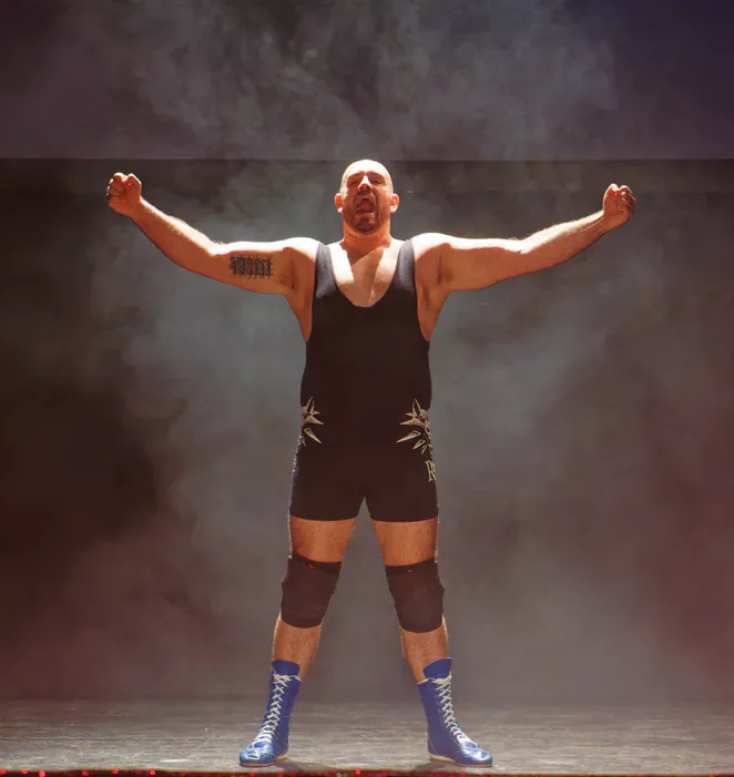 A wrestler raising both arms.