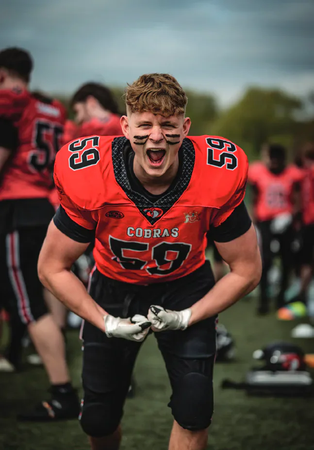 A Cardiff Cobras American football player celebrating on the field.
