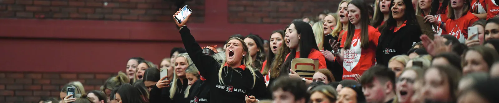 Cardiff students cheering from the stands during Welsh Varsity.