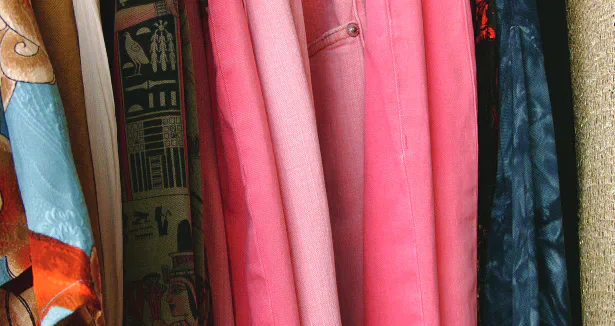 A rail of colourful second-hand clothes.