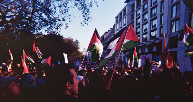 A street demonstration with Palestinian flags.