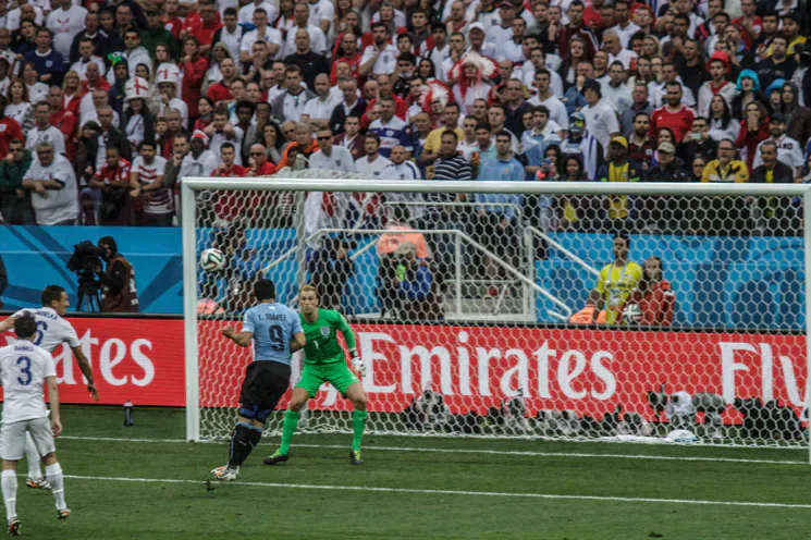 Joe Hart facing a penalty kick for England during a football match.