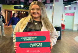 Catrin Edith holds a Vice President Cymraeg election sign.