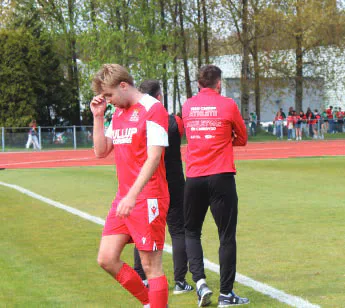 Cardiff football player walking beside the pitch