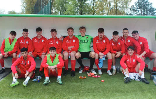 Cardiff football squad seated beside the pitch