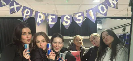 Expression Dance members posing beneath an Expression banner