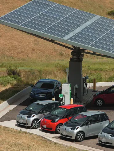 Electric cars charging beneath a solar-panel canopy