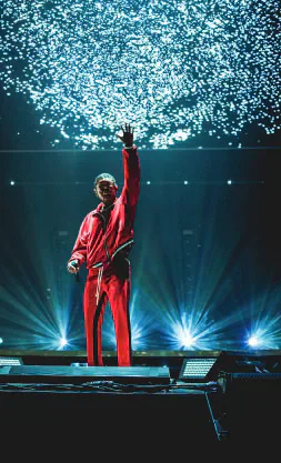 Kendrick Lamar performing on a stage in a red outfit