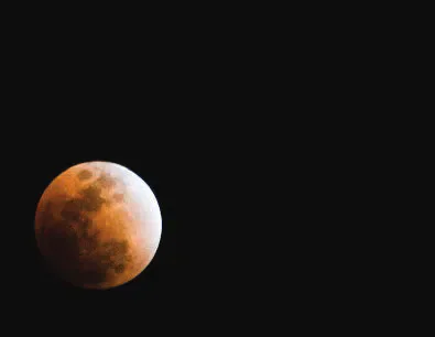 The moon during a lunar eclipse against a black sky