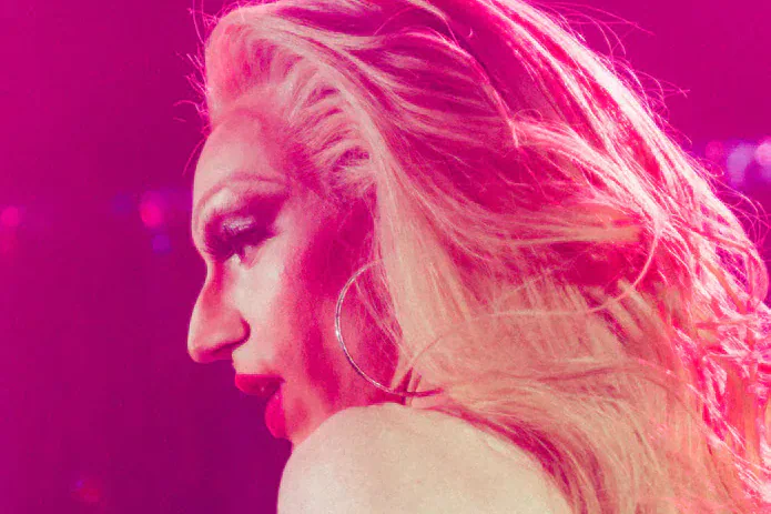 A performer under vivid pink stage lighting at the Iris Prize.