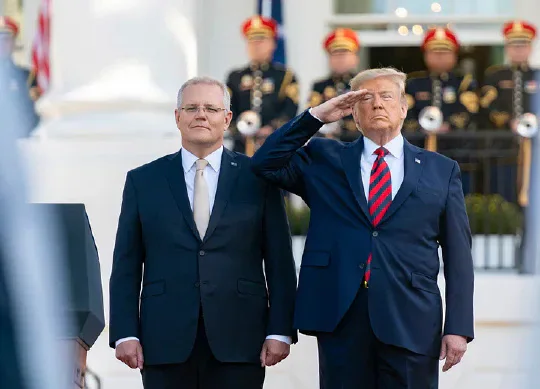 Donald Trump saluting beside Scott Morrison outside the White House.