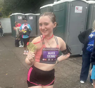 Alice holding her Cardiff Half Marathon medal.