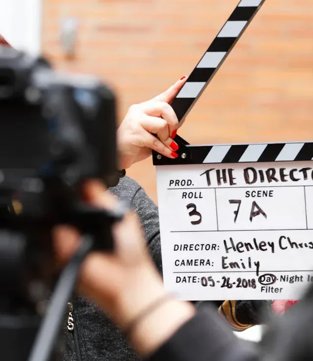 A film crew using a clapperboard in front of a camera.