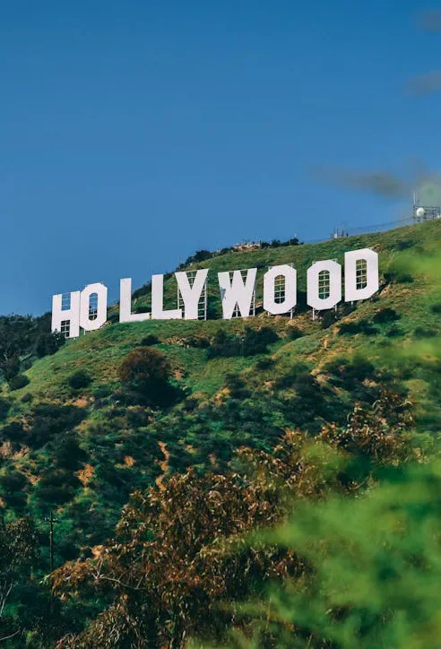 The Hollywood sign on a hillside beneath a blue sky.