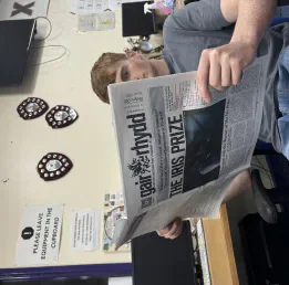 A student reading a copy of Gair Rhydd in the editorial office.