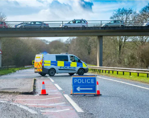 A police van and road-closure signs blocking a dual carriageway.