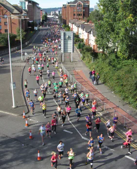 Runners taking part in the Cardiff Half Marathon on a city road.