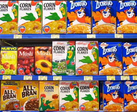 Boxes of Kellogg’s and other cereals displayed on supermarket shelves.