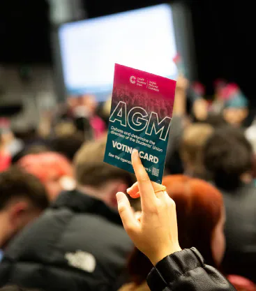 A student holding an AGM voting card.