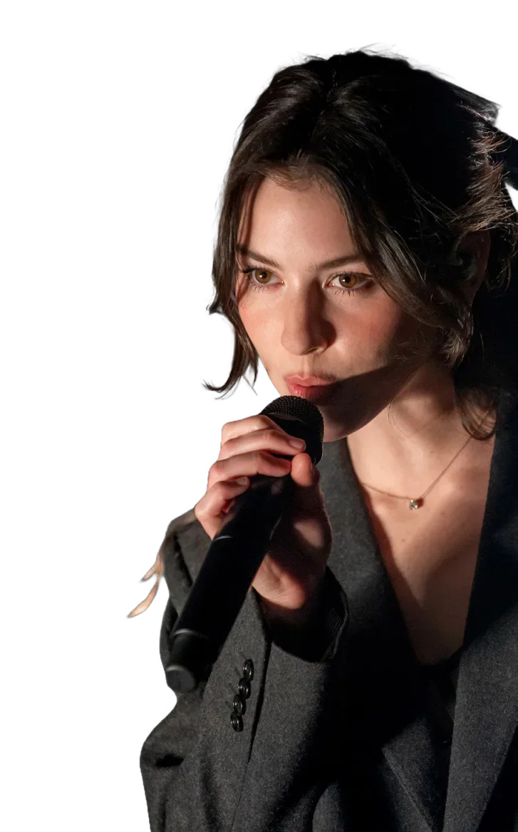 Gracie Abrams singing into a microphone.