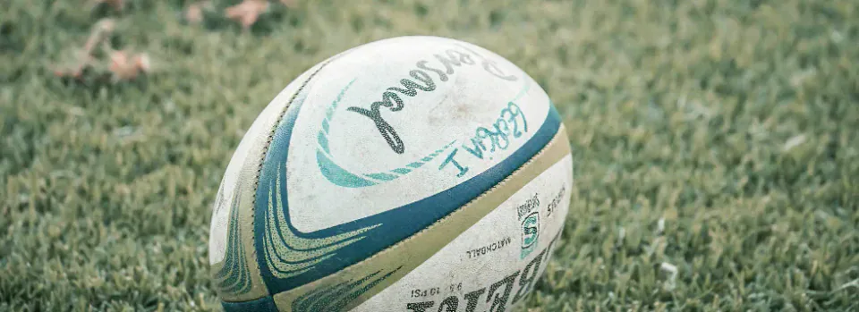 A rugby ball lying on grass.