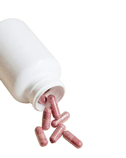 A tipped white bottle spilling red capsules.