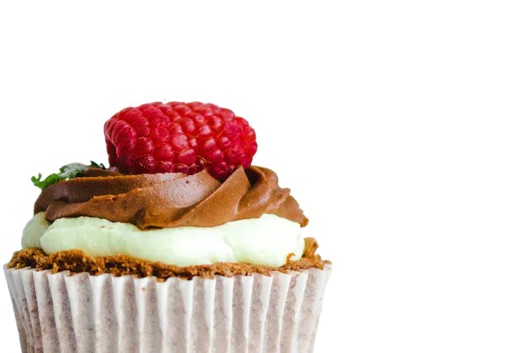 A cupcake topped with cream, chocolate and a raspberry